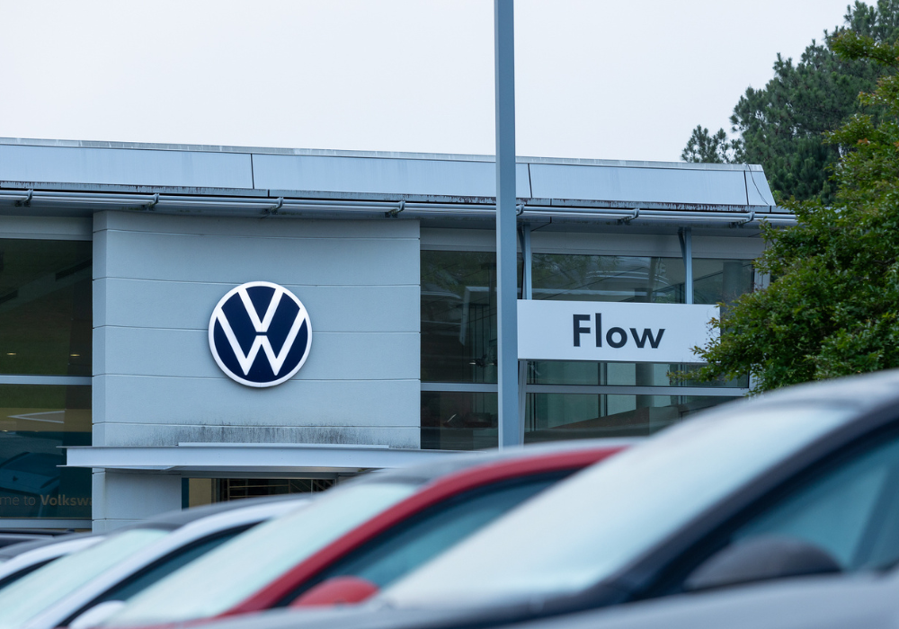 Exterior of the a Volkswagen dealership in Wilmington, NC. The Flow logo and VW logo are visible on the front of the building